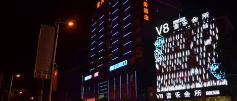 A multi-story building with illuminated signage, including a prominent 'V8' sign.