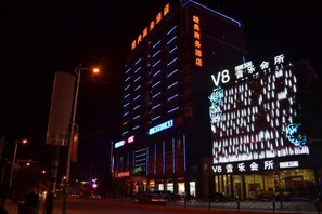 A multi-story building with illuminated signage, including a prominent 'V8' sign. - Jingdian Hotel (Nan'an)