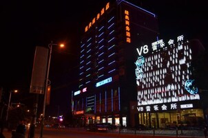 A multi-story building with illuminated signage, including a prominent 'V8' sign.