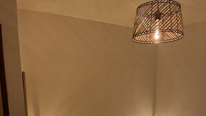 Ein Schlafzimmer mit einem Bett, einem Nachttisch und einer Pendelleuchte.