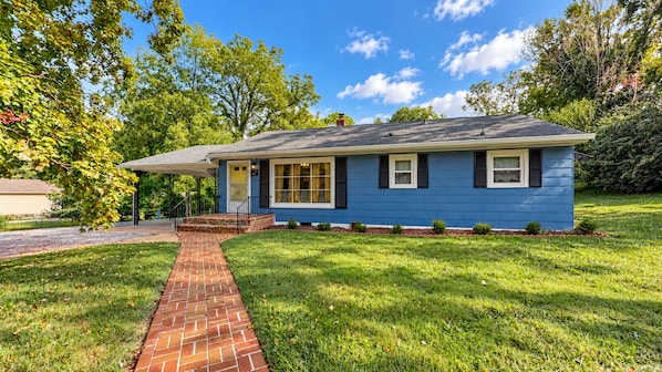 A single-story house with a brick pathway leading to the front door.