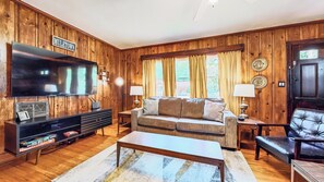 Una sala de estar con televisor, sofá, mesa de centro y un letrero que dice 'Mule Town'.