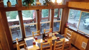 Un comedor de madera con una mesa dispuesta para cuatro personas, rodeada de sillas.