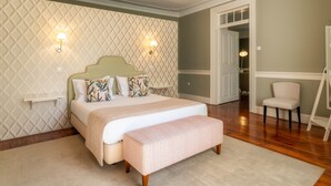 Una camera da letto con un letto, comodini, una panca e una sedia.