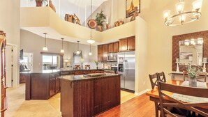 A spacious kitchen with a large island, wooden cabinets, and modern appliances. - Spacious, Family Friendly Condo with Lake View - The Majestic at Table Rock (Branson)