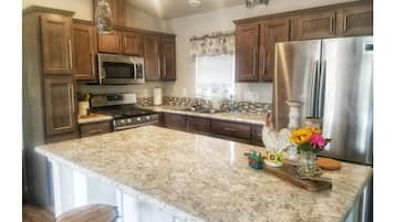 Enjoy cooking in this well-equipped kitchen with a large island, stainless steel appliances, and ample storage.