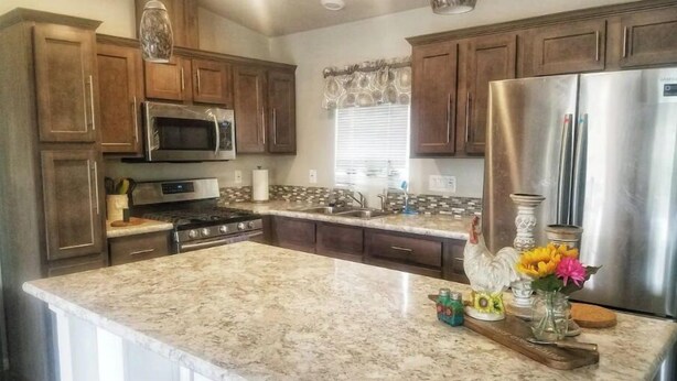 A kitchen with granite countertops, stainless steel appliances, wooden cabinets, and a central island. - Zion Fence Line - Walk to Trailhead  - Secluded (Orderville)