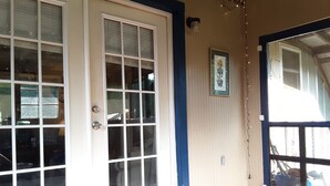 A room with a large sliding glass door, a framed picture on the wall, and a doormat on the floor. - Quiet Barn Loft at Rock'n'Rose (Morganton)
