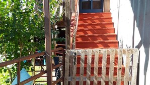 A wooden staircase leading to a door, surrounded by a metal fence and a gravel path. - Quiet Barn Loft at Rock'n'Rose (Morganton)