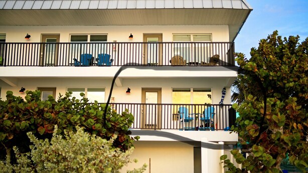 A multi-story building with balconies, a door, and a window.
