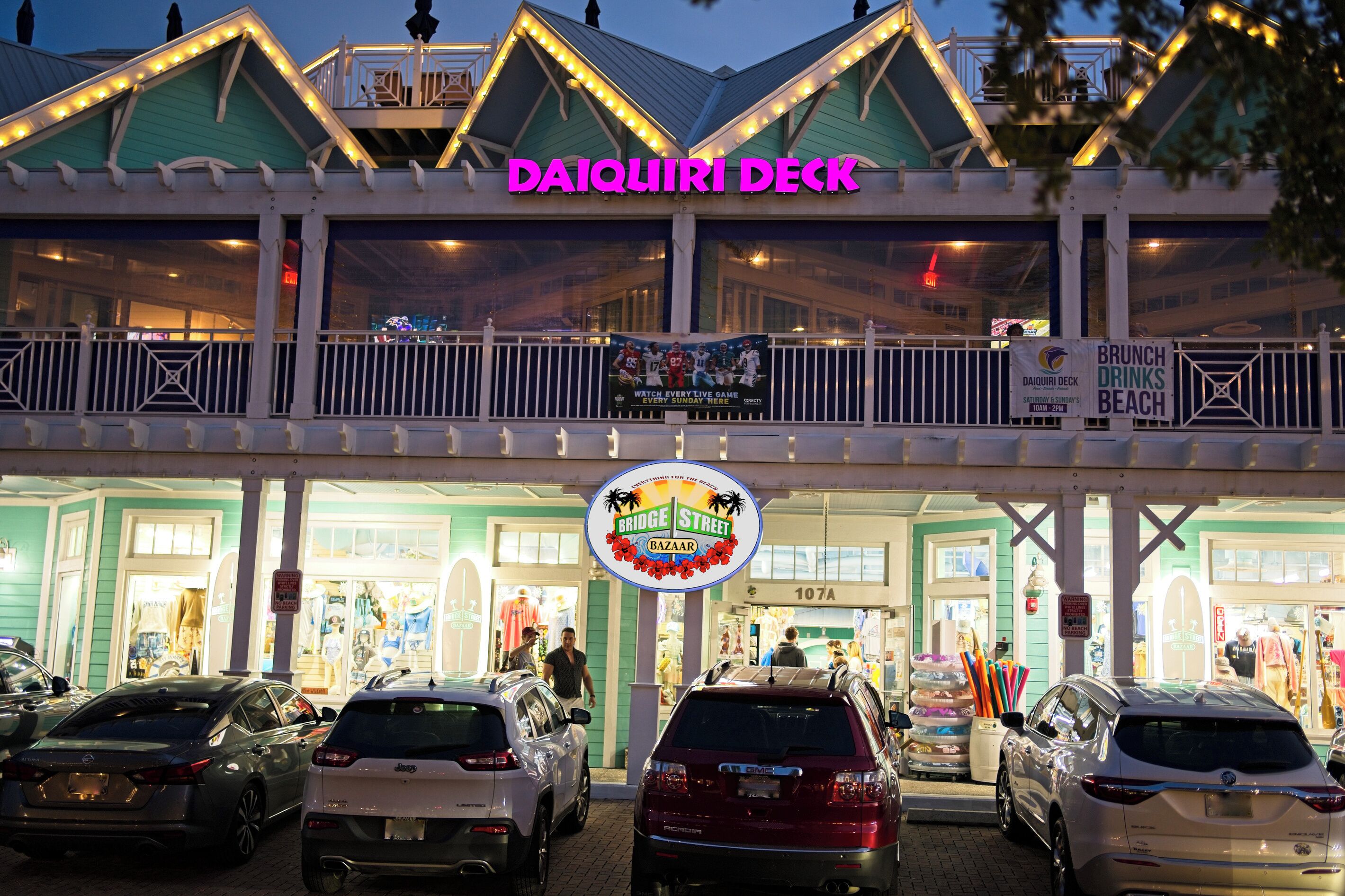 A multi-level building with a sign reading 'DAIQUIRI DECK' and a 'BRIDGE STREET BAZAAR' sign.