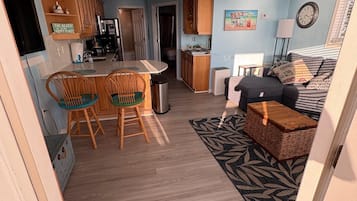 Un espace de vie compact comprenant un coin cuisine, un coin repas et une chambre avec un canapé et un lit.