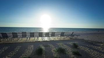 Una spiaggia con lettini disposti su un pontile di legno, affacciata sull'oceano.