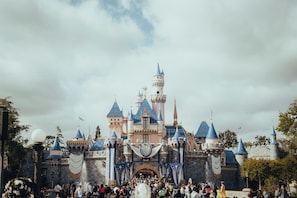 A castle-like structure with multiple towers and a crowd of people in front. - King Studio Suite w/ Full Kitchen + Free Breakfast (Anaheim)