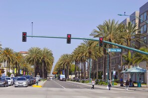 Una intersección con semáforos, palmeras y un edificio con un letrero que dice 'Harbor Blvd'.