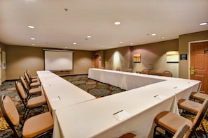A conference room with a long table, chairs, a projector screen, and a carpeted floor. - Free Breakfast Pool & Hot Tub. Near East Towne Mall! (Madison)