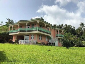 Stunning two-story building with a central balcony and beautifully manicured lawn.