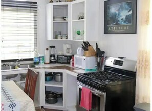 Kitchen area with stove, microwave, coffee maker, and sink, perfect for preparing meals.
