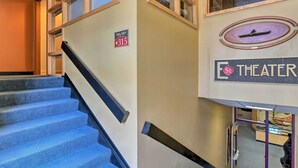 A staircase leading to a theater with a sign indicating the theater's location. - Idyllic Dtwn Anchorage Condo w/ Fireplace! (Anchorage)