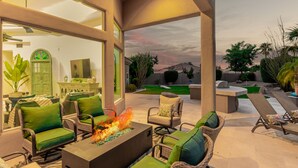 An outdoor patio with wicker furniture, a fire feature, and a view of the backyard. - 4BR w pool, heated spa, fire pit (Mesa)