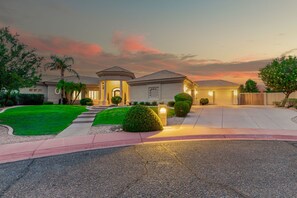 A residential house with a well-maintained lawn, a covered porch, and a garage. - 4BR w pool, heated spa, fire pit (Mesa)