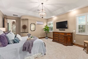 A bedroom with a bed, dresser, TV, and a potted plant. - 4BR w pool, heated spa, fire pit (Mesa)