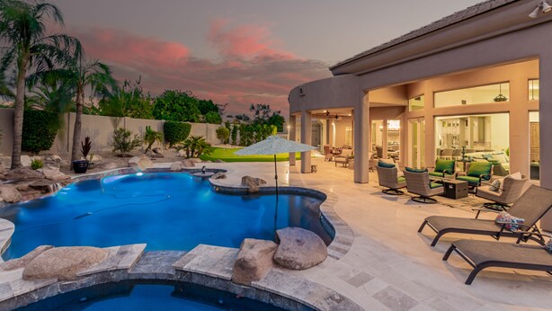 A swimming pool with rock features, lounge chairs, and a patio area with outdoor furniture. - 4BR w pool, heated spa, fire pit (Mesa)