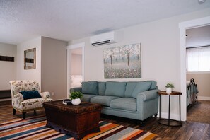 A living room with a sofa, armchair, and a coffee table.