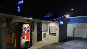 A motel with a Pepsi vending machine, a sign for 'DIXIE NO', and a neon sign indicating 'OFFICE'.