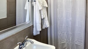 A bathroom with a white sink, a mirror, and a shower curtain.