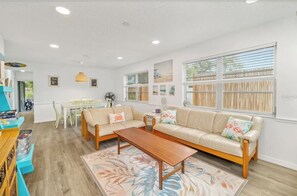 Un salon moderne comprenant un canapé, une table basse et un coin repas avec une table et des chaises.