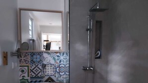 A bathroom with a white sink, a mirror, and a shower. - Les Anses D'arlet Superbe Studio Proche Plage (Les Anses-d'Arlet)