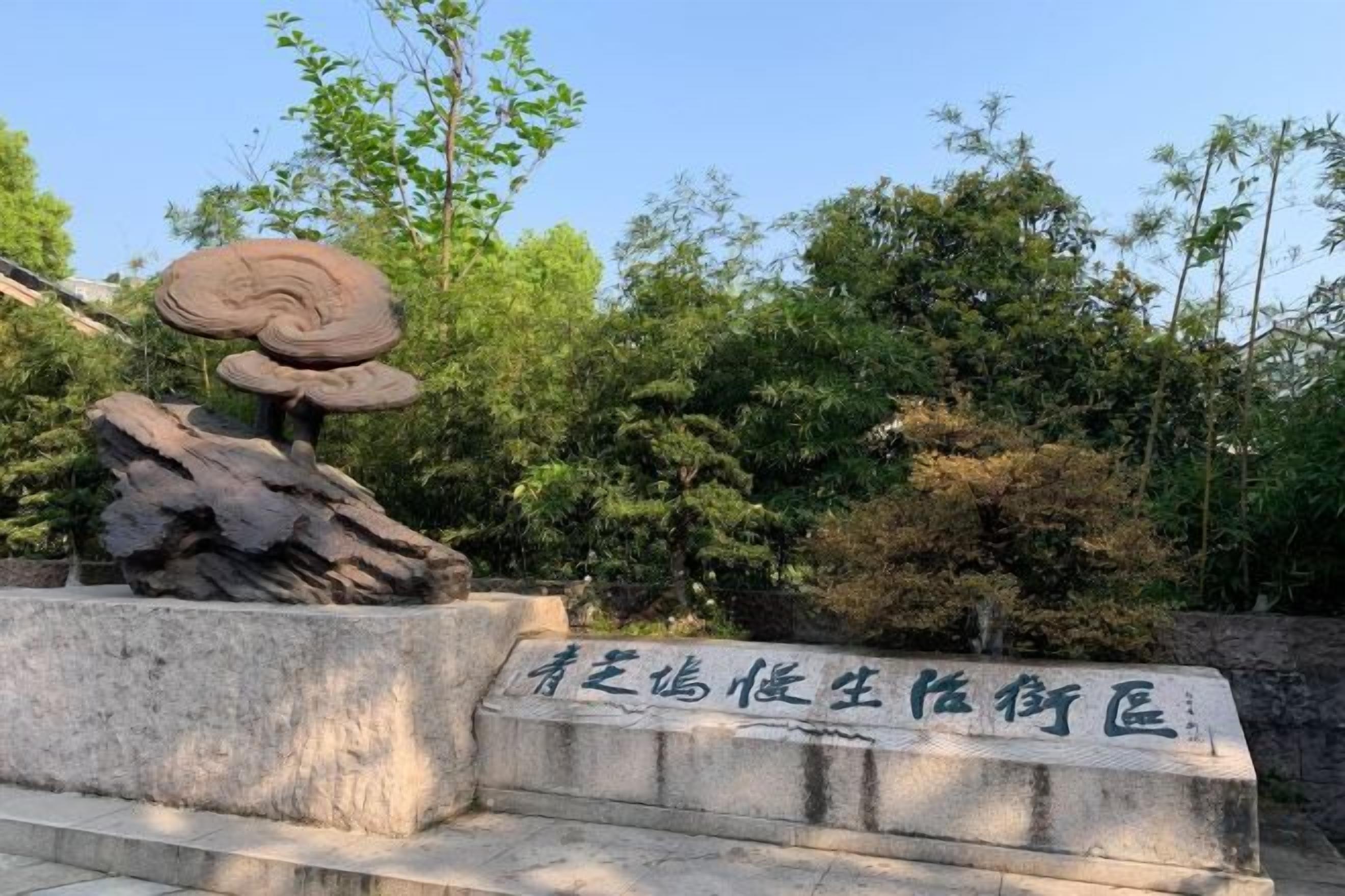 Une sculpture en pierre représentant des champignons et une plaque portant une inscription.