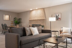 Relax in this stylish living room with a sofa, coffee table, and fireplace.