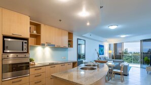 A modern kitchen with built-in appliances, a dining area with a view, and a spacious living room.