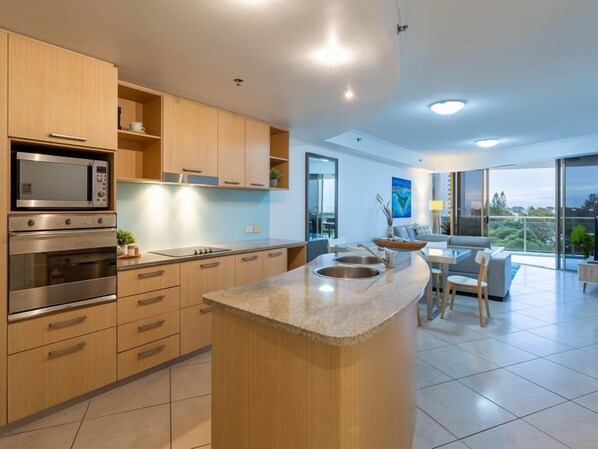 A modern kitchen with built-in appliances, a dining area with a view, and a spacious living room.