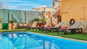 A swimming pool with lounge chairs and umbrellas, a stone wall, and a staircase leading to an upper level. - Stunning private villa for 6 people with WIFI, private pool, A/C, TV, terrace and pets allowed (Maçanet De La Selva)