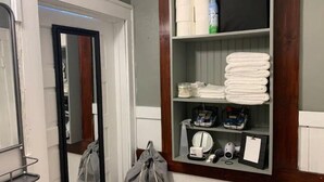 A bathroom with a mirror, shelves with toiletries, towels, and a hairdryer. - Entire house for fishing, hunting, or passing by! (Fairfax)