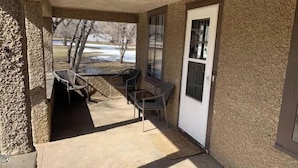 A covered patio area with a concrete floor, a door, and a window. - Entire house for fishing, hunting, or passing by! (Fairfax)
