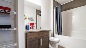 Ein modernes Badezimmer mit Toilette, einer Duschkabine und einem Waschtisch mit Spiegel.