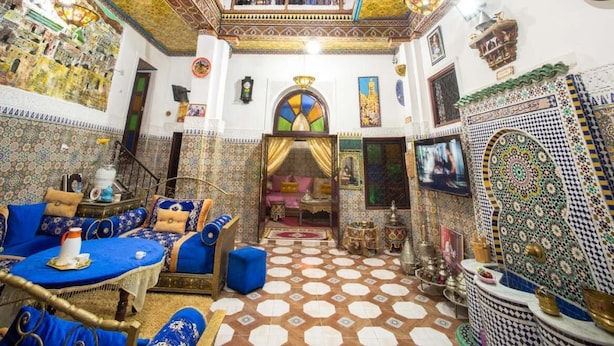 A richly decorated interior with a patterned floor, a sofa set, and a dining area. - RIAD ABQARI YOUSSEFI (Fes)