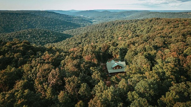 A remote cabin surrounded by dense forest with a clear view of the valley below. - Stone's Mountain View (Altamont)