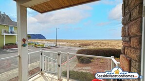Ein Balkon mit Blick auf den Strand und ein Berg in der Ferne.