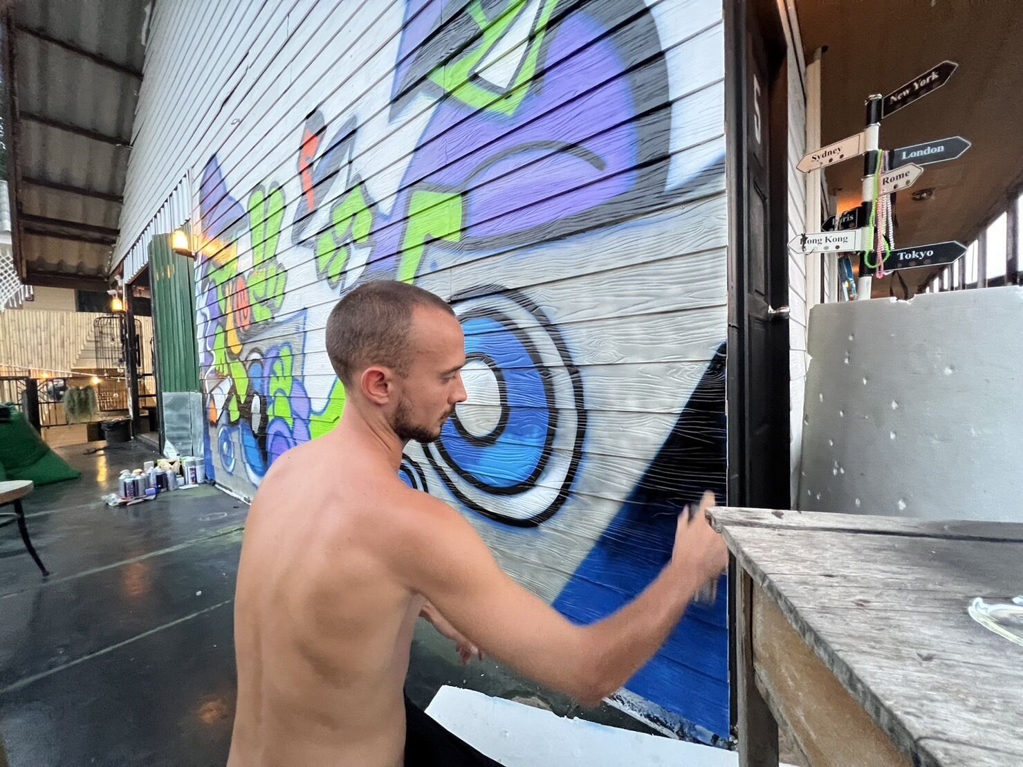 A person painting a colorful mural on a building's exterior wall.