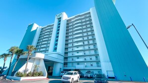 A multi-story hotel with a modern design, featuring a prominent curved structure and a series of balconies. - ⛱️SummerChase 904⛱️ indoor pool, hot tub, kiddie pool, gym, and beach towels (Orange Beach)