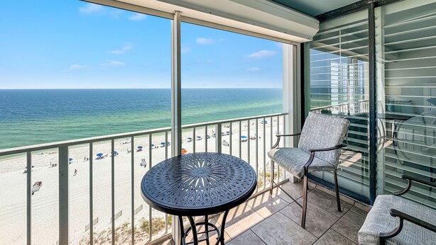 A balcony with a view of the ocean, a round table, and two chairs. - ⛱️SummerChase 904⛱️ indoor pool, hot tub, kiddie pool, gym, and beach towels (Orange Beach)