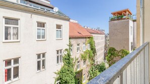 En smal gade med bygninger på begge sider, der viser en blanding af arkitektoniske stilarter, heriblandt en bygning med rødt tag og en anden med balkon.