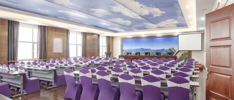 A conference room with a long table, chairs, and a cityscape mural on the wall.
