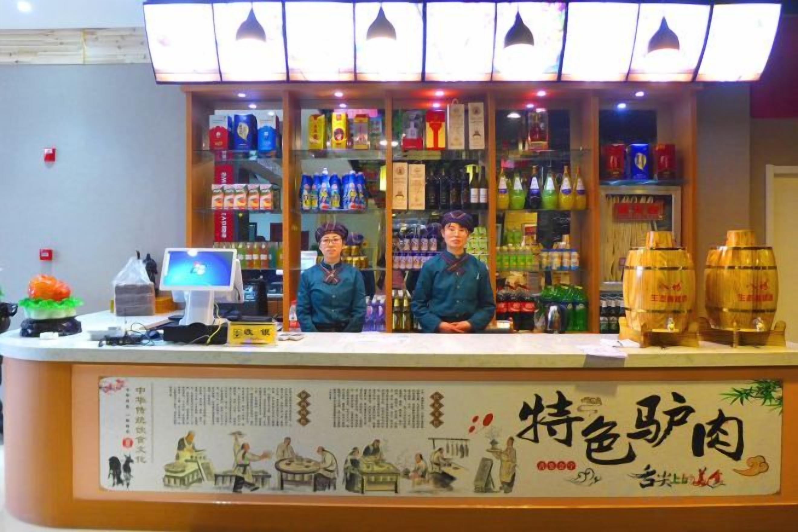 A counter with a display of various beverages and a menu board.