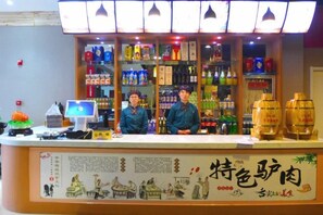 A counter with a display of various beverages and a menu board. - Xiyan International Hotel (Huining)